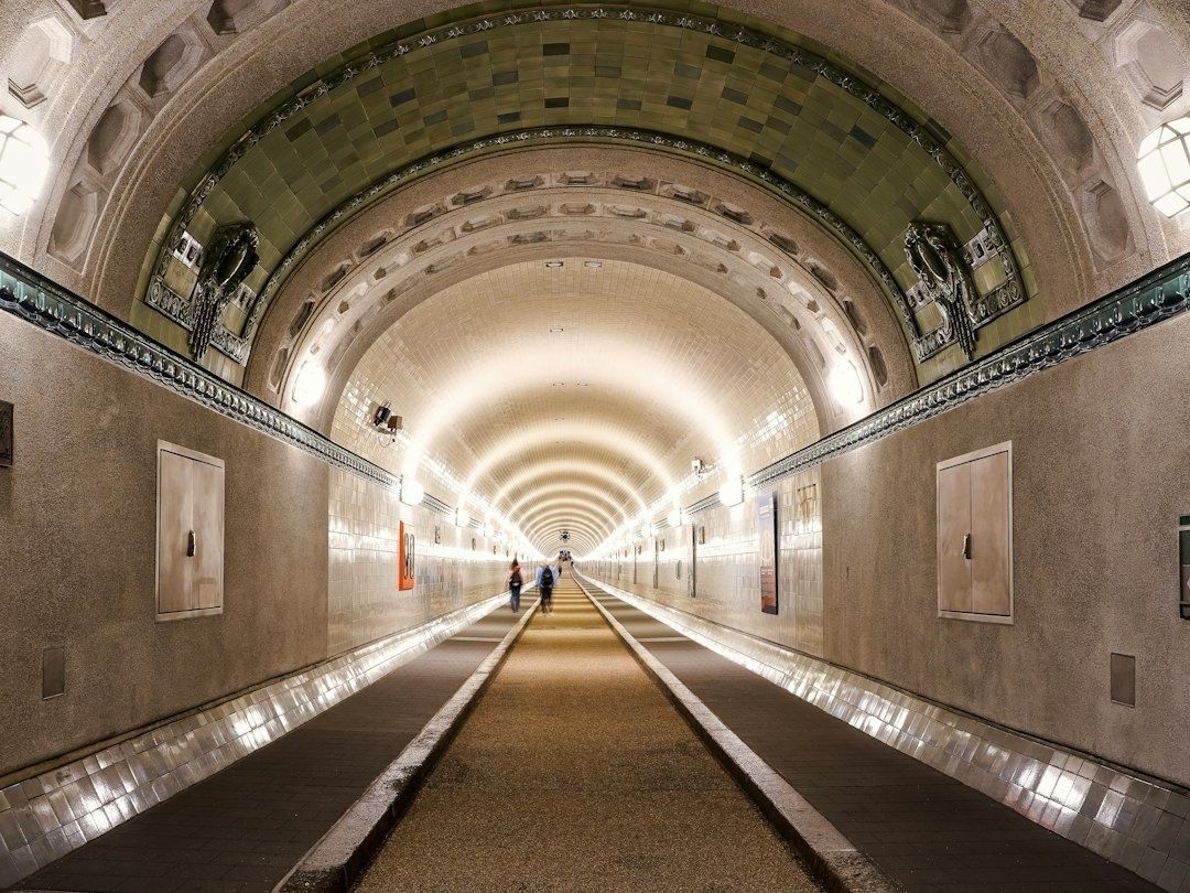 Valaistu, koristeellinen pitkä jalankulkutunneli holvikatolla